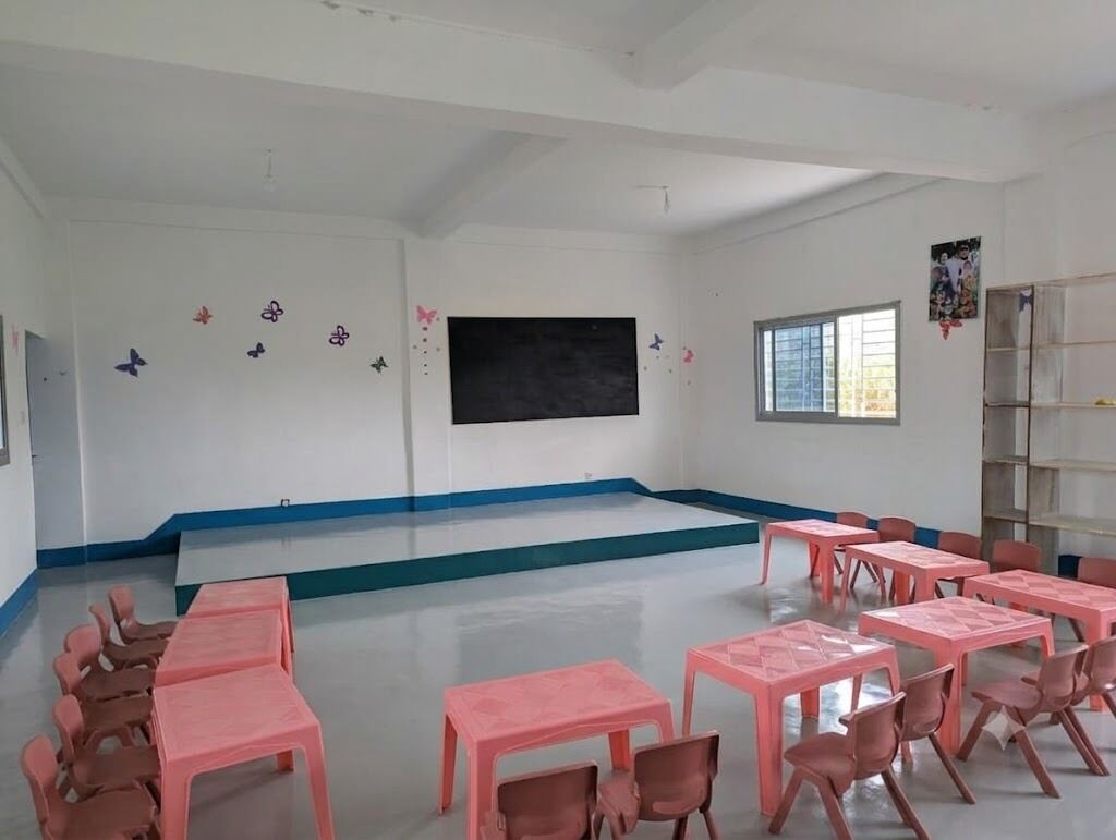 Classroom with pink child-sized tables and chairs