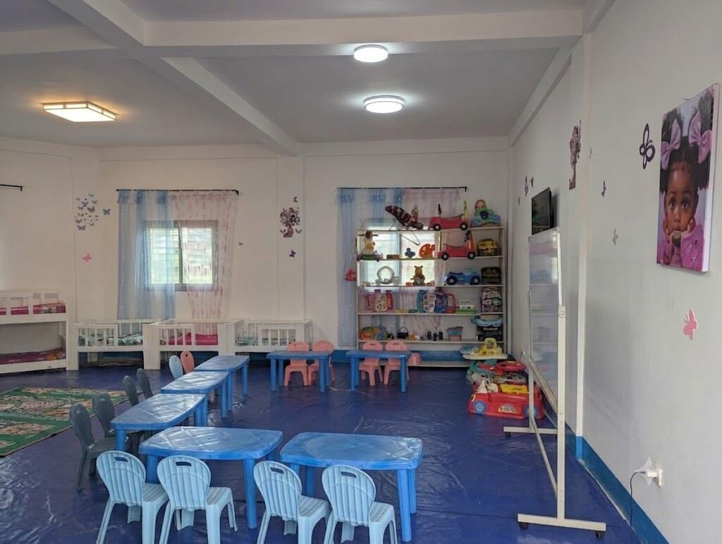 Daycare room with cots and a toy shelf