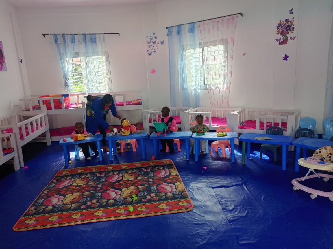 Daycare caretaker attending to toddlers at play