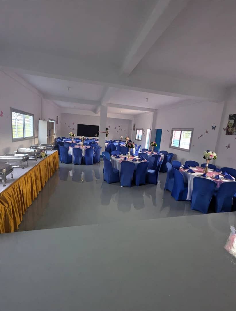 Event hall set up with blue chairs and round tables